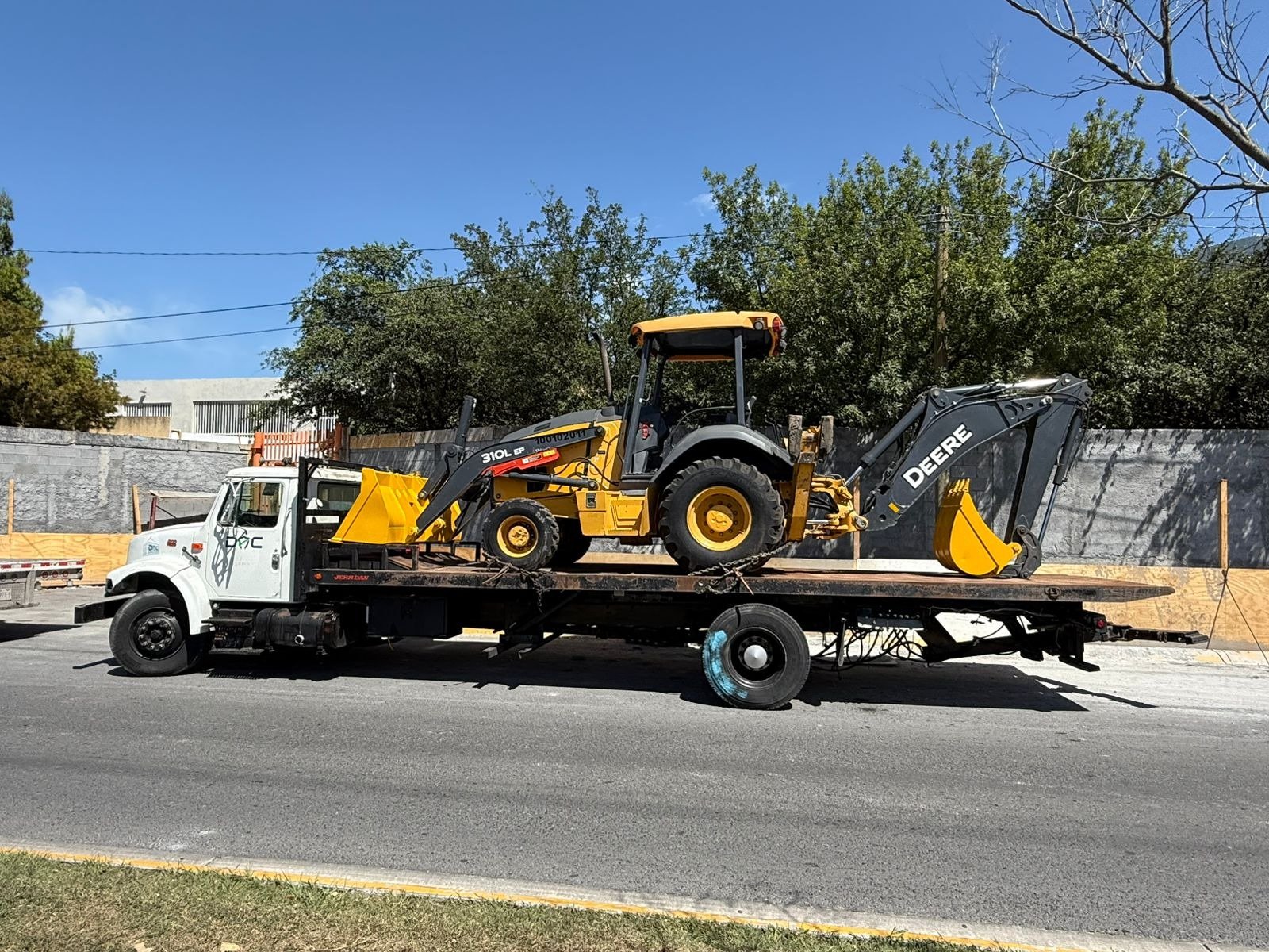 Traslado de retroexcavadora Deere en plataforma