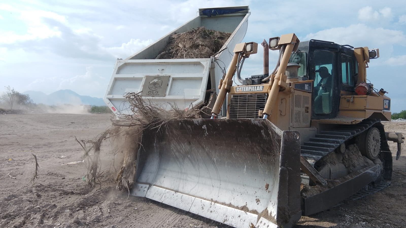 Bulldozer CAT de OLG TRUCKING moviendo tierra y escombro