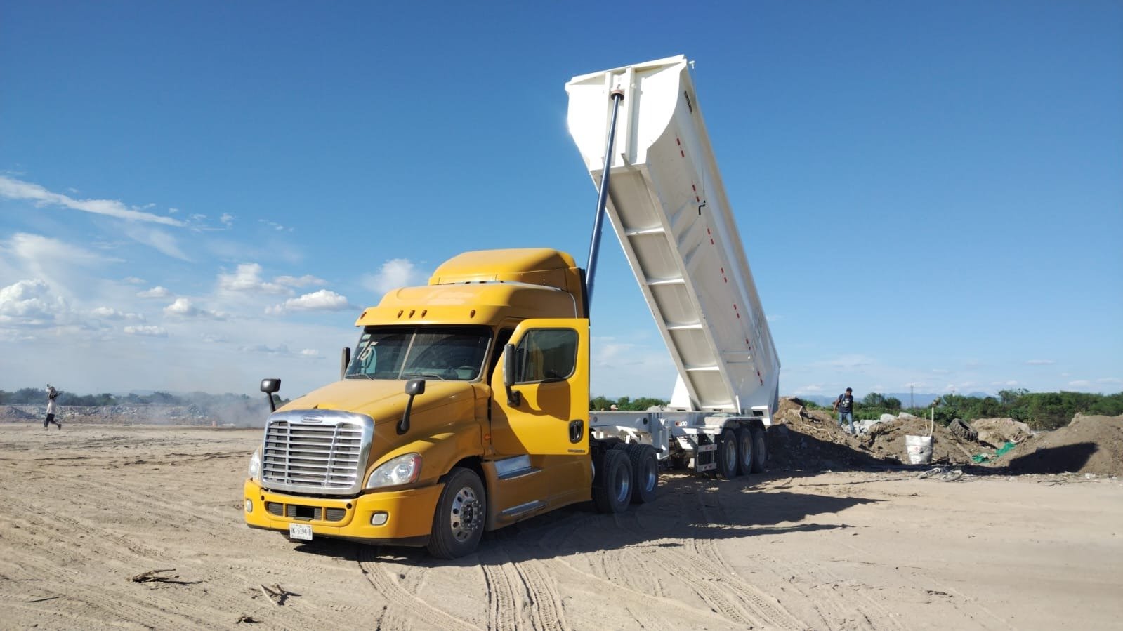 Camión de volteo de OLG TRUCKING descargando material