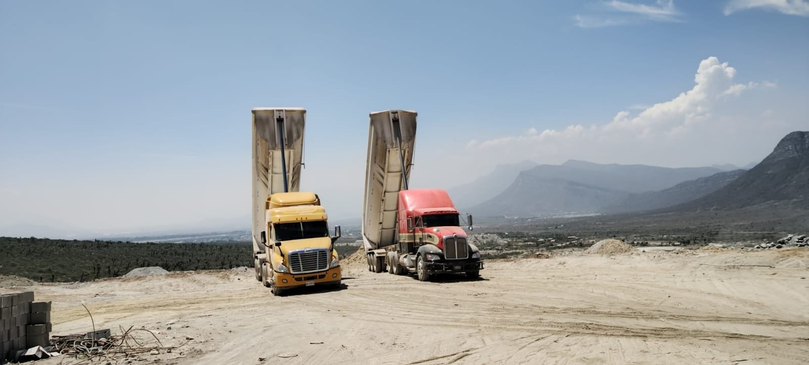 Camiones de volteo de OLG TRUCKING descargando en la Sierra