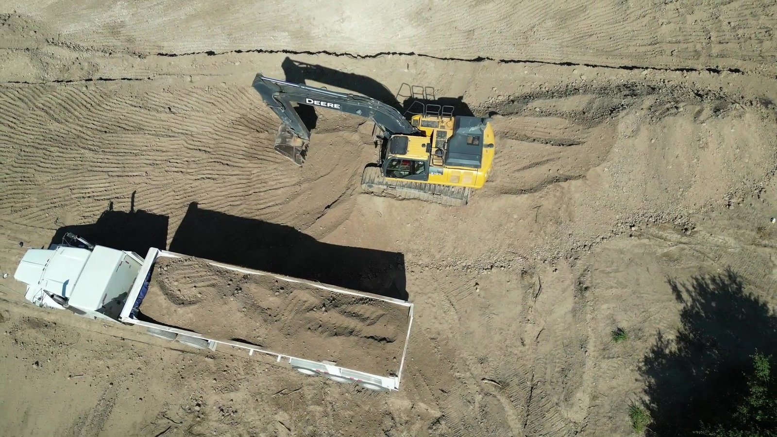 Vista aérea de excavadora cargando camión de OLG TRUCKING